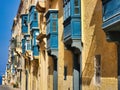 European city. Close up. Balcony of an apartment building with flowers. House in cracks. Beautiful summer cityscape. Colorful