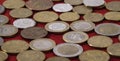 European coins on red cloth, selective focus, close-up