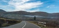 European country road. Turn right, road sign, trees and bright blue sky. Asphalt and dry grass.