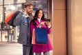 European couple enjoying online shopping on smartphone standing near mall Royalty Free Stock Photo