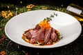 European cuisine. Marinated veal with roast Medium rare. Degree of roasting. Chef pours beef olive oil. Serving dishes