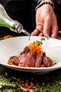 European cuisine. Marinated veal with roast Medium rare. Degree of roasting. Chef pours beef olive oil. Serving dishes Royalty Free Stock Photo