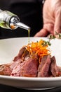 European cuisine. Marinated veal with roast Medium rare. Degree of roasting. Chef pours beef olive oil. Serving dishes Royalty Free Stock Photo