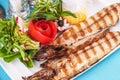 Steak of river fish with white meat, served with vegetables, lemon and arugula and tomato salad Royalty Free Stock Photo