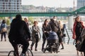 European Family, a father and mother, and their baby, in a stroller, walking wearing face mask in a middle of a crowd on Covid