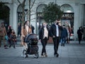 European Family, a father and mother, and their baby, in a stroller, walking wearing face mask protective equipement on covid