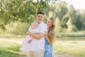 A European family in the park on a summer day. Happy and smiling mom, dad and little son in their arms. Dad plus size Royalty Free Stock Photo