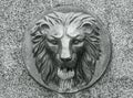 European figure relief metal bronze lion head concept photo. Water fountain installed on a stone wall. Royalty Free Stock Photo