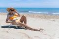 european girl in a hat and swimsuit relaxes and lies on a sun lounger on the beach alone, Royalty Free Stock Photo