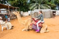 A European girl riding an Arabian Camel in the Heritage folk village in Abu Dhabi, United Arab Emirates