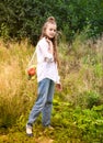 European girl 1 years old in a white shirt carries a bag of vegetables on the background of nature