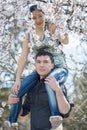 European guy carrying his asian girl in blossoming park