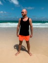 European hairless bearded man male guy standing on the beach in black sleeveless shirt singlet with empty space for text or print Royalty Free Stock Photo