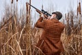 young hunter is hunting in forest, looking through the rifle, soft focus. in countryside