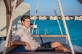 European handsome man wearing shirt and shorts relaxing on the sofa at tropical beach at island luxury resort Royalty Free Stock Photo