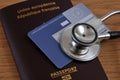 European health insurance card and stethoscope lying on a European Union passport close up