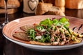 European Italian cuisine. Warm salad of veal, fried arugula, cucumber, mix lettuce, dried tomatoes, sweet peppers and cheese Royalty Free Stock Photo