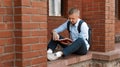 European male student sitting near the library and reading a book Royalty Free Stock Photo