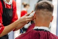 European man is cut by a barber. Men& x27;s haircutting with hair clipper Royalty Free Stock Photo