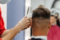 European man is cut by a barber. Men& x27;s haircutting with hair clipper Royalty Free Stock Photo