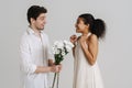 European man giving black woman chrysanthemum bouquet