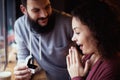 A European man holds in his hand and shows the engagement ring to his amazed girl in a cafe, a girlfriend in ecstasy. The concept Royalty Free Stock Photo