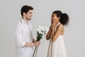 European man giving black woman chrysanthemum bouquet