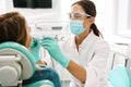 European mid dentist woman in face mask working in dental clinic