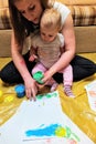 Mother and daughter do handprints with green paint Royalty Free Stock Photo