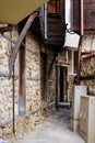 European narrow cobble-paved street between yellow classic houses in the old town. Bulgarian traditional small passage between Royalty Free Stock Photo