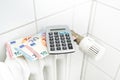 European notes and a calculator on an old heater, concept for saving energy costs during inflation, copy space, selected focus