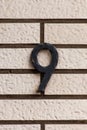 Number 9 black metal house number on white tile wall Royalty Free Stock Photo