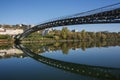 European pedestrian bridge reflected in the river in autumn