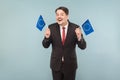 European politician holds flags and toothy smiling