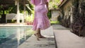 European pregnant girl  stay in the backyard with a green garden in a beautiful long pink dress Royalty Free Stock Photo