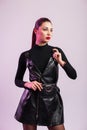 European pretty young woman fashion model with red lips with trendy hairstyle in leather fashion black dress posing near vintage Royalty Free Stock Photo