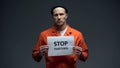 European prisoner holding stop tortures sign, physical abuse in cell, harassment