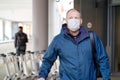 European redbeard man is in protective medical mask in airport