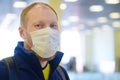 European redbeard man is in protective medical mask in airport.