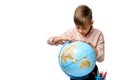 European schoolboy carefully looks at the globe in geography lesson