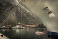 Marine sea port with moored cruise nautical vessel in medieval Kotor bay in Montenegro in overcast rainy autumn day