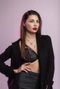 European sensual young woman with red lips in a long jacket in vintage striped trousers in a sexy fashionable lace lingerie posing Royalty Free Stock Photo