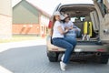 European single-parent family and Jack Russell puppy travel by car. Toddler with his mother and a small dog are sitting