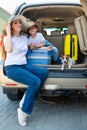 European single-parent family and Jack Russell puppy travel by car. Toddler with his mother and a small dog are sitting