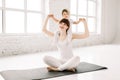 European sportive mother piggybacking her toddler baby girl in fitness clothing on loft window background. Mother Royalty Free Stock Photo