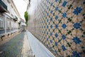 European street with old wall with traditional Portuguese decor tiles azulezhu in blue,yellow and brown tones. Royalty Free Stock Photo