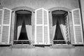 Two windows with curtains and open wooden shutters Royalty Free Stock Photo