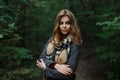 European sweet young woman with blond hair in a luxurious gray coat with a checkered vintage scarf posing in a park Royalty Free Stock Photo