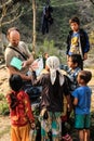 European tourists give notebooks, pens and school supplies to poor Nepalese children. Volunteer assistance to poor children in the