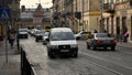 Cars driving by old Lviv city street with busy traffic